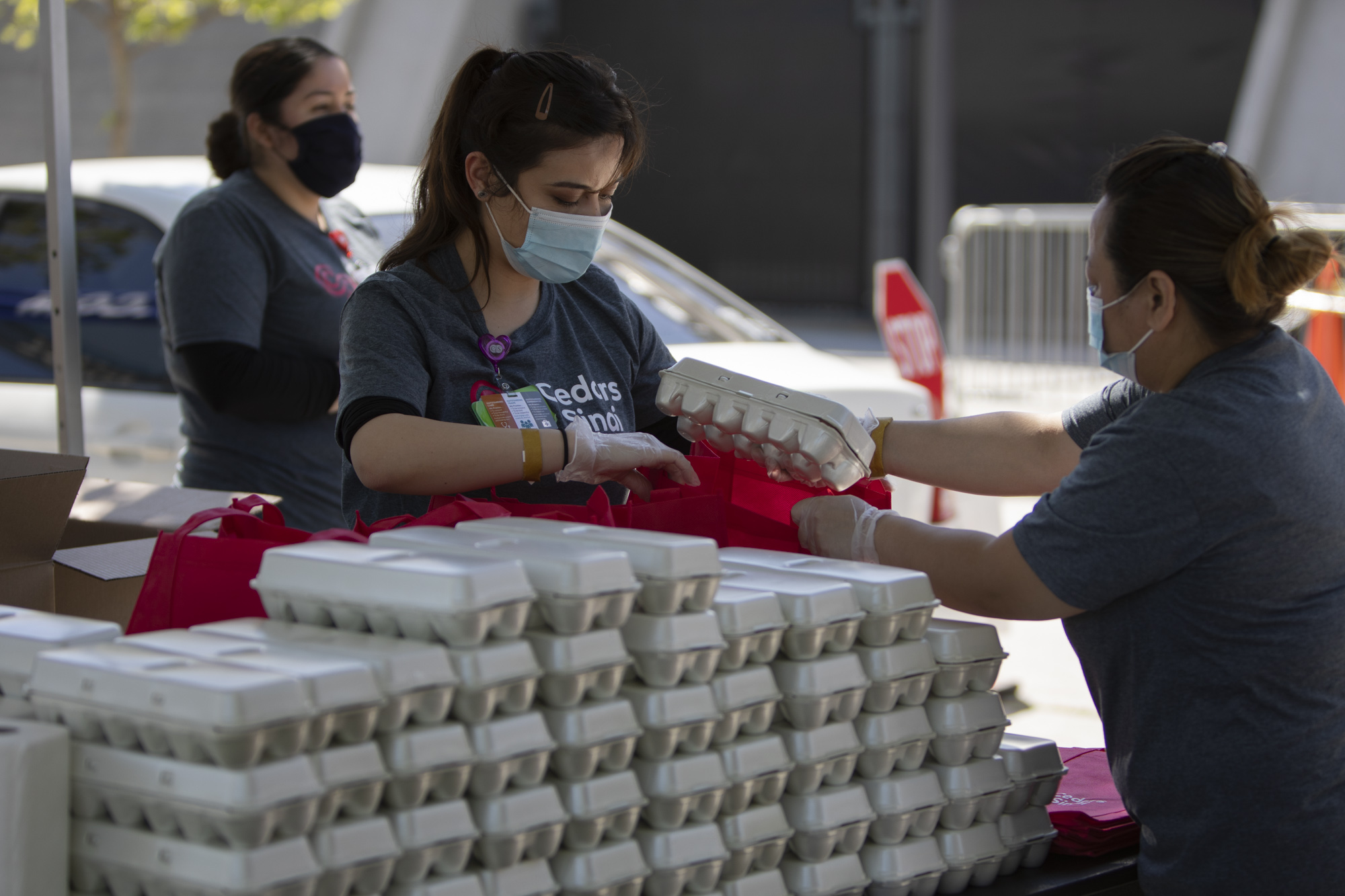 Representatives from Cedars-Sinai prepare bags with a dozen eggs. Each family also receives a week’s worth of seasonal fruits and vegetables, 10 pounds of oranges, and information about local public nutrition benefit and incentive programs.