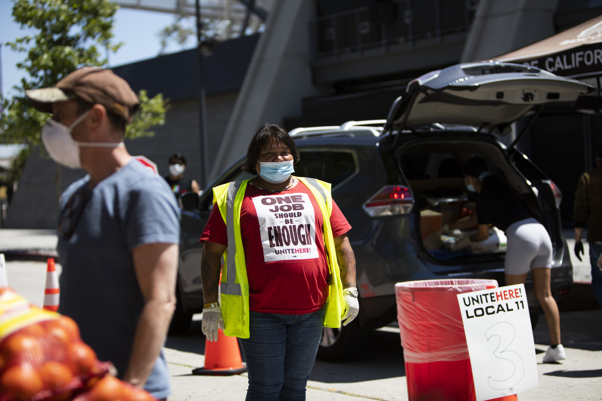 Ana Diaz, of UNITE HERE Local 11, waits to direct vehicles out of the area after their car is packed.