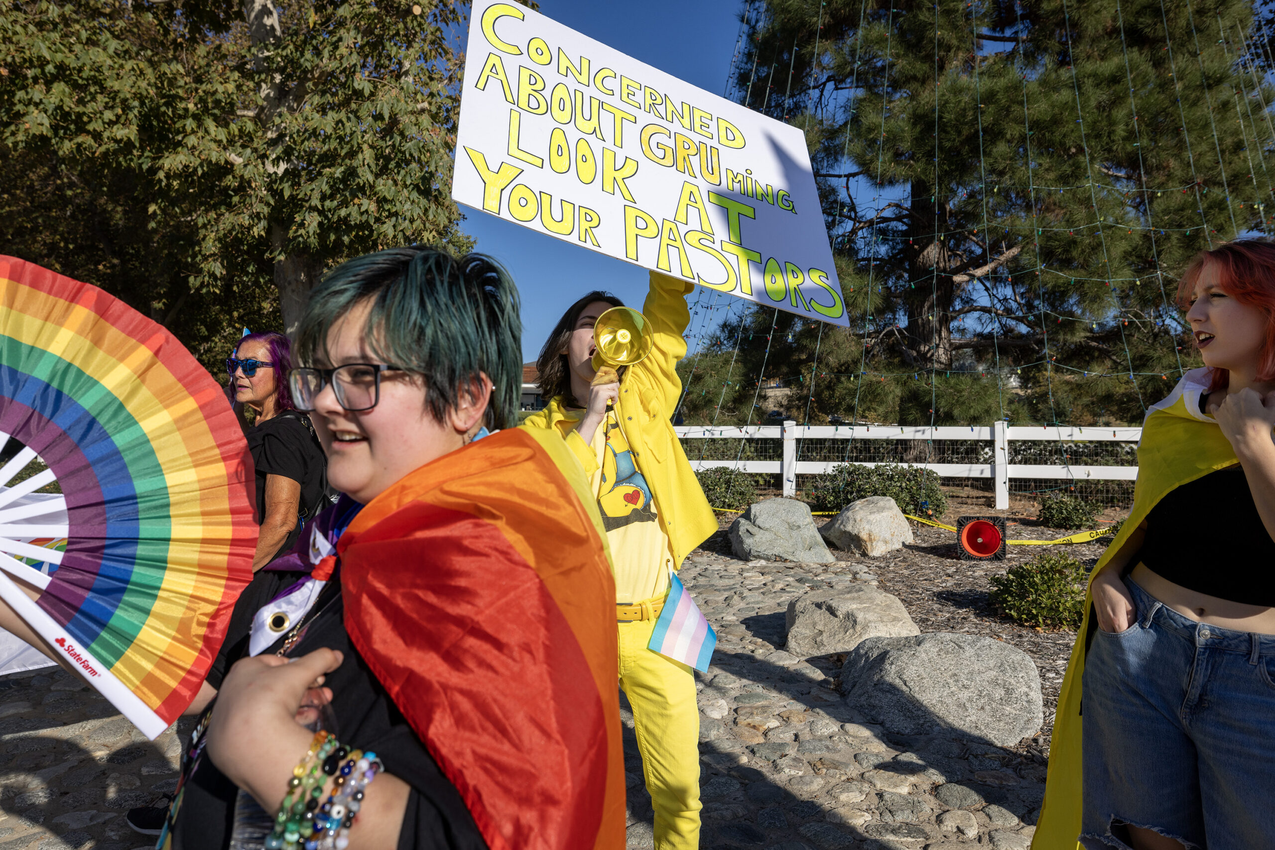 Moxxie Child, a 16-year-old transgender student, left (holding a fan), attends the rally in Temecula on Nov. 12. “I stand before you not just as an activist but as someone deeply concerned about the critical issues plaguing Temecula’s schools and students, jeopardizing our right to a quality education.”